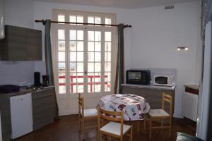 a kitchen with a table and chairs and a kitchen with a window at La Précieuse in Mers-les-Bains
