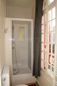 a bathroom with a shower with a toilet and a window at La Précieuse in Mers-les-Bains