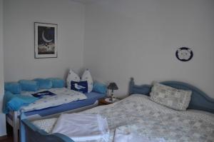 a bedroom with two beds and a clock on the wall at FeWo Möwennest Felstehausen GM 69252 in Graal-Müritz +2 photos