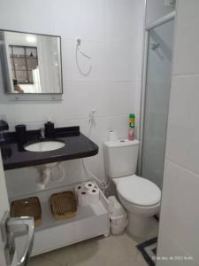 y baño con aseo, lavabo y espejo. en Apt aconchegante na Ponta Verde, en Maceió