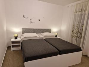 a bedroom with a large bed and two night stands at Holiday Home Gabriela in Sukošan