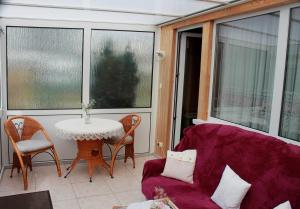 a living room with a purple couch and a table at Haus 2 - Haus Behaglich Heinrich GM 69368 in Graal +12 photos