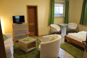 un soggiorno con mobili bianchi e TV di Haus Birkenallee Reckleben GM 69705 a Graal-Müritz