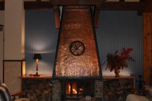 a fireplace with a clock on top of it at Hotel Calitxo in Molló