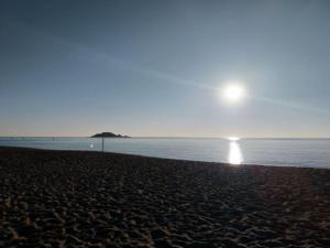 una playa con el sol saliendo sobre el agua en Da Fra e La, en Girasole