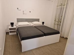 - une chambre blanche avec un lit doté d'une tête de lit gris dans l'établissement Holiday Home Gabriela, à Sukošan