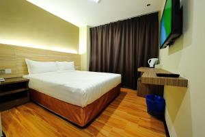 a hotel room with a bed and a television at U Design Hotel Bukit Mertajam in Bukit Mertajam