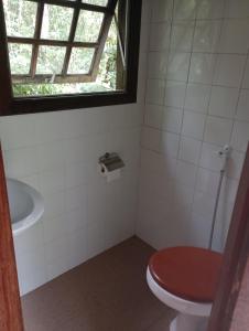 a bathroom with a toilet and a sink and a window at Gran Camping Cabanas da Fazenda in Visconde De Maua