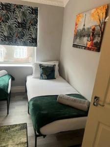 Kleines Zimmer mit einem Bett und einem Fenster in der Unterkunft Affordable Newly Refurbished 3 Bedroom House, Sleeps 7, NG8 Postcode in Nottingham