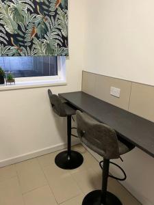 a black desk with a chair and a window at Affordable Newly Refurbished 3 Bedroom House, Sleeps 7, NG8 Postcode in Nottingham