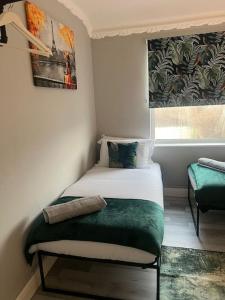 ein kleines Schlafzimmer mit einem Bett und einem Fenster in der Unterkunft Affordable Newly Refurbished 3 Bedroom House, Sleeps 7, NG8 Postcode in Nottingham