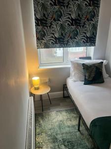 ein Schlafzimmer mit einem Bett und einem Tisch mit einem Fenster in der Unterkunft Affordable Newly Refurbished 3 Bedroom House, Sleeps 7, NG8 Postcode in Nottingham