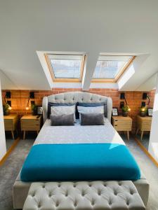 a bedroom with a large bed with two skylights at Apartament MoLoo II in Ostróda