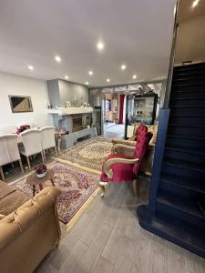 uma sala de estar com sofás e uma escada numa casa em Villa*proche Aeroport et gares . em Viry-Châtillon