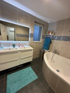 ein Badezimmer mit einer Badewanne, einem Waschbecken und einer Badewanne in der Unterkunft Villa*proche Aeroport et gares . in Viry-Châtillon