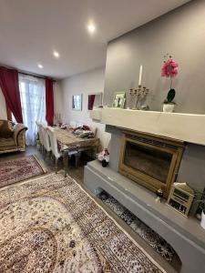 ein Wohnzimmer mit einem Kamin und einem Esstisch in der Unterkunft Villa*proche Aeroport et gares . in Viry-Châtillon