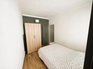 Dormitorio pequeño con cama y armario en Appartement 2 pièces, proche RER, Bus et chateau, en Rambouillet