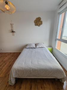 a bedroom with a bed and a window at Studio Disneyland Paris 10min/Val d'Europe 5min/Wifi/TV in Montévrain