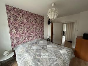 a bedroom with a bed with a pink floral wall at Zollhaus 26 in Hohegeiß