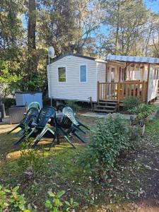 a group of chairs sitting in front of a tiny house at Mobil home 6 personnes in Saint-Brevin-les-Pins