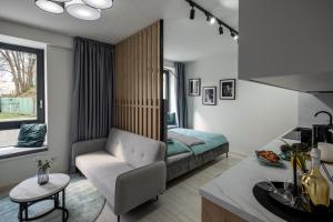 - un salon avec un lit, un canapé et une chaise dans l'établissement Apartment EDIAS, à Banská Bystrica