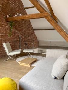 a living room with a couch and a chair at Unique design triplex with rooftop terrace in Mechelen