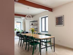 a dining room with a table and green chairs at Unique design triplex with rooftop terrace in Mechelen