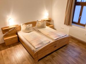 ein Schlafzimmer mit einem Holzbett mit Kissen darauf in der Unterkunft Ferienwohnung Morgensonne am Kurpark in Bad Berka