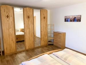 Schlafzimmer mit Holzwänden, einem Bett und einem Spiegel in der Unterkunft Ferienwohnung Morgensonne am Kurpark in Bad Berka