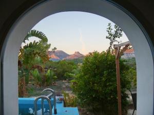 an archway with a view of a garden and mountains at Finca Caracol in Bolulla +8 photos