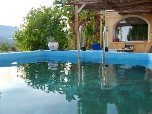 a swimming pool with blue water in front of a house at Finca Caracol in Bolulla
