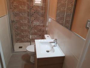 a bathroom with a toilet and a sink and a shower at Sevilla Nervión piso con Patio in Seville