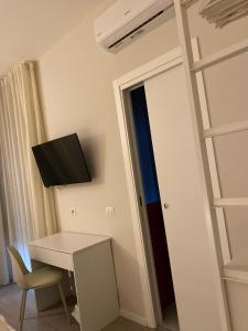 een kamer met een bureau en een tv aan de muur bij Midtown Salerno in Salerno