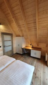 1 dormitorio con 1 cama y escritorio en una habitación en Osada Swory domki w lesie nad jeziorem, en Małe Swornigacie