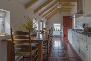 a large kitchen with a wooden table and chairs at 't Kruushuus in Welsum