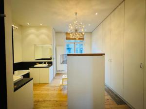 a white kitchen with a chandelier in a room at Amazing 3 bedrooms - Place Brugmann in Brussels