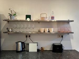 a kitchen with shelves with glasses on it at Amazing 3 bedrooms - Place Brugmann in Brussels