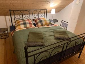 een slaapkamer met een groot groen bed met kussens bij Ferienhaus // Waldlerhaus - Bayern - Bayerischer Wald in Windberg
