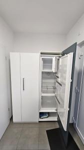 a white refrigerator with its door open in a room at Ferienwohnung Hesse Ilsede in Ilsede