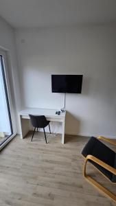 a room with a desk with a television and a chair at Ferienwohnung Hesse Ilsede in Ilsede