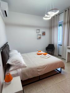 a white bedroom with a bed and a chair at Puzzle Rooms in Campobasso