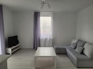 Biały salon z kanapą i stołem w obiekcie Apartament Mistral w Krakowie