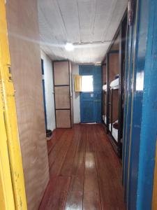 Cette chambre vide est dotée de parquet et d'un couloir avec des portes. dans l'établissement Posada Chambranas, à Salento