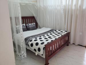 ein Bett mit einer schwarzen und weißen Bettdecke und Kissen in der Unterkunft First Mayor' Garden in Malamagambo