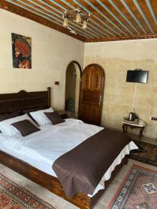 1 dormitorio con 1 cama grande en una habitación en Cappadocia Cave Sinasos Villa, en Mustafapaşa