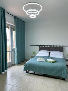 a bedroom with a large bed with green sheets and a chandelier at Puzzle Rooms in Campobasso