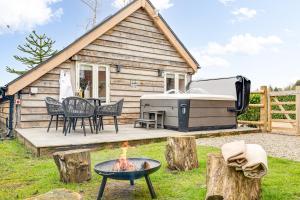 a tiny house with a grill and a table and chairs at Oak Tree Hideaway in Whitchurch