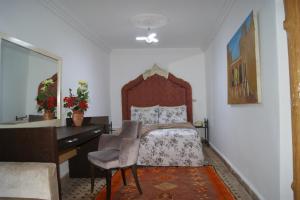 Schlafzimmer mit einem Bett, einem Schreibtisch und einem Stuhl in der Unterkunft Villa Ayche in Marrakesch
