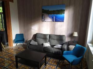 uma sala de estar com um sofá e duas cadeiras azuis em Lac des Settons - Gîte 3* La Grignette em Moux-en-Morvan
