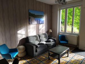 uma sala de estar com um sofá e duas cadeiras azuis em Lac des Settons - Gîte 3* La Grignette em Moux-en-Morvan